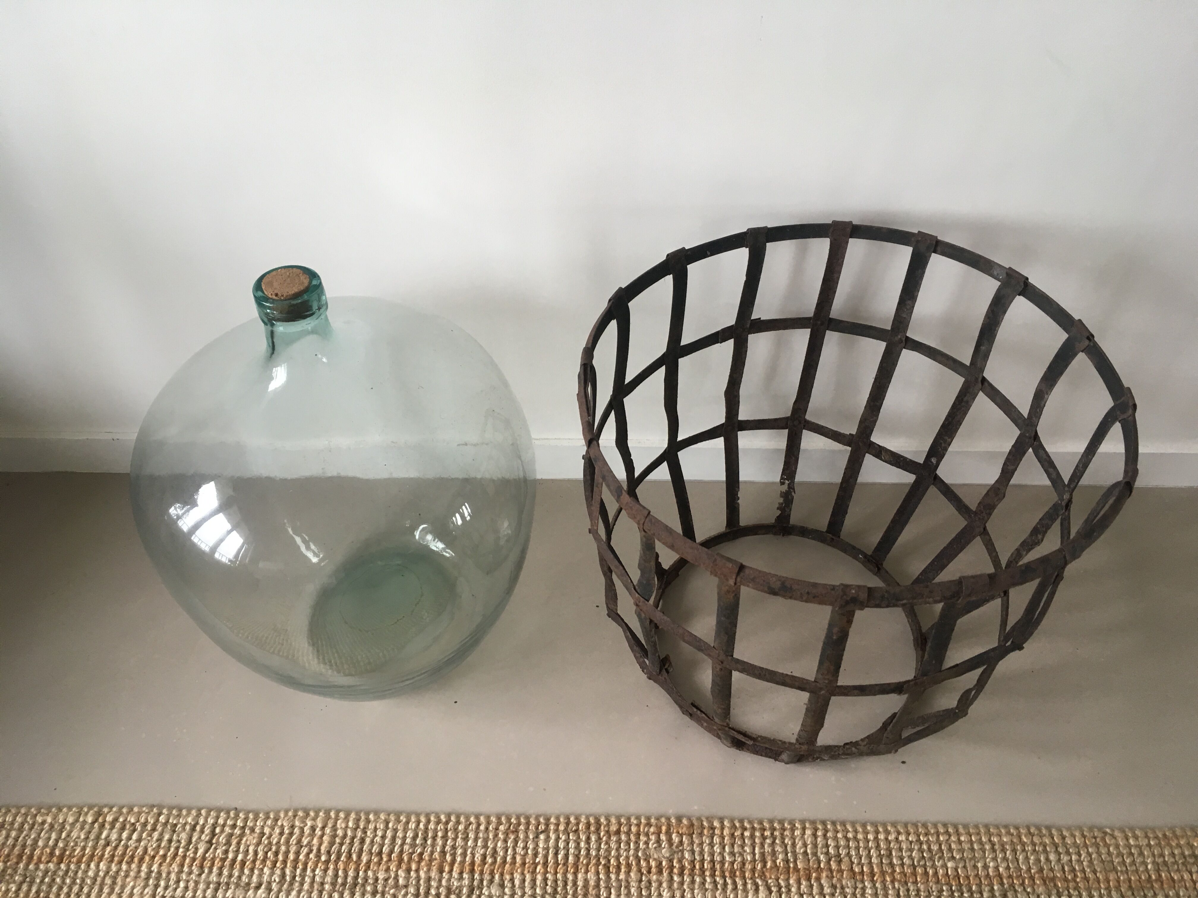 Old demijohn and her metal basket