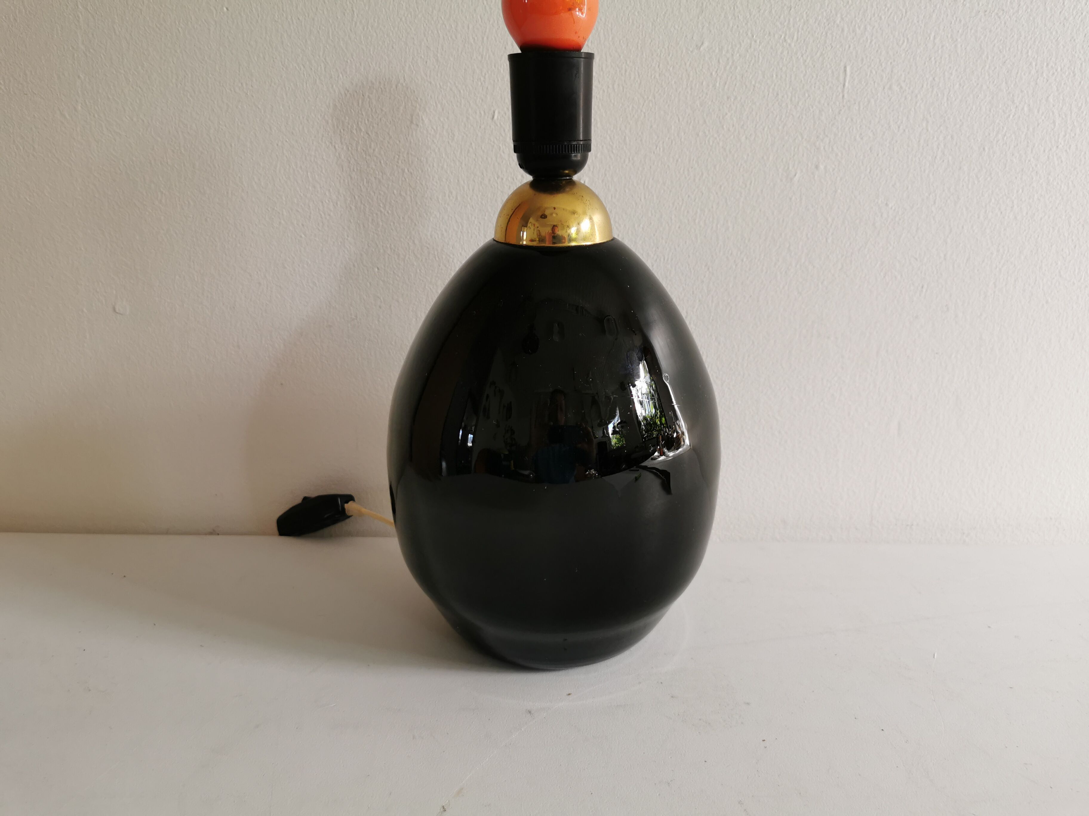 Table lamp, made of handmade coal-black glass, with brass coloured top.