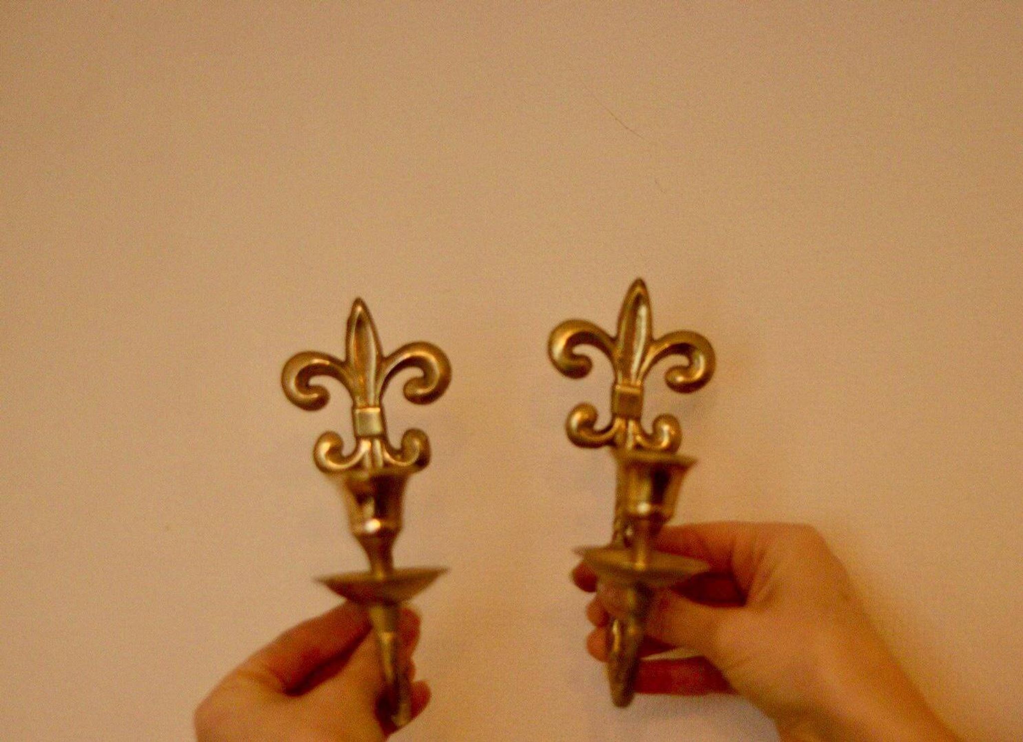 A pair of antique brass wall sconces.