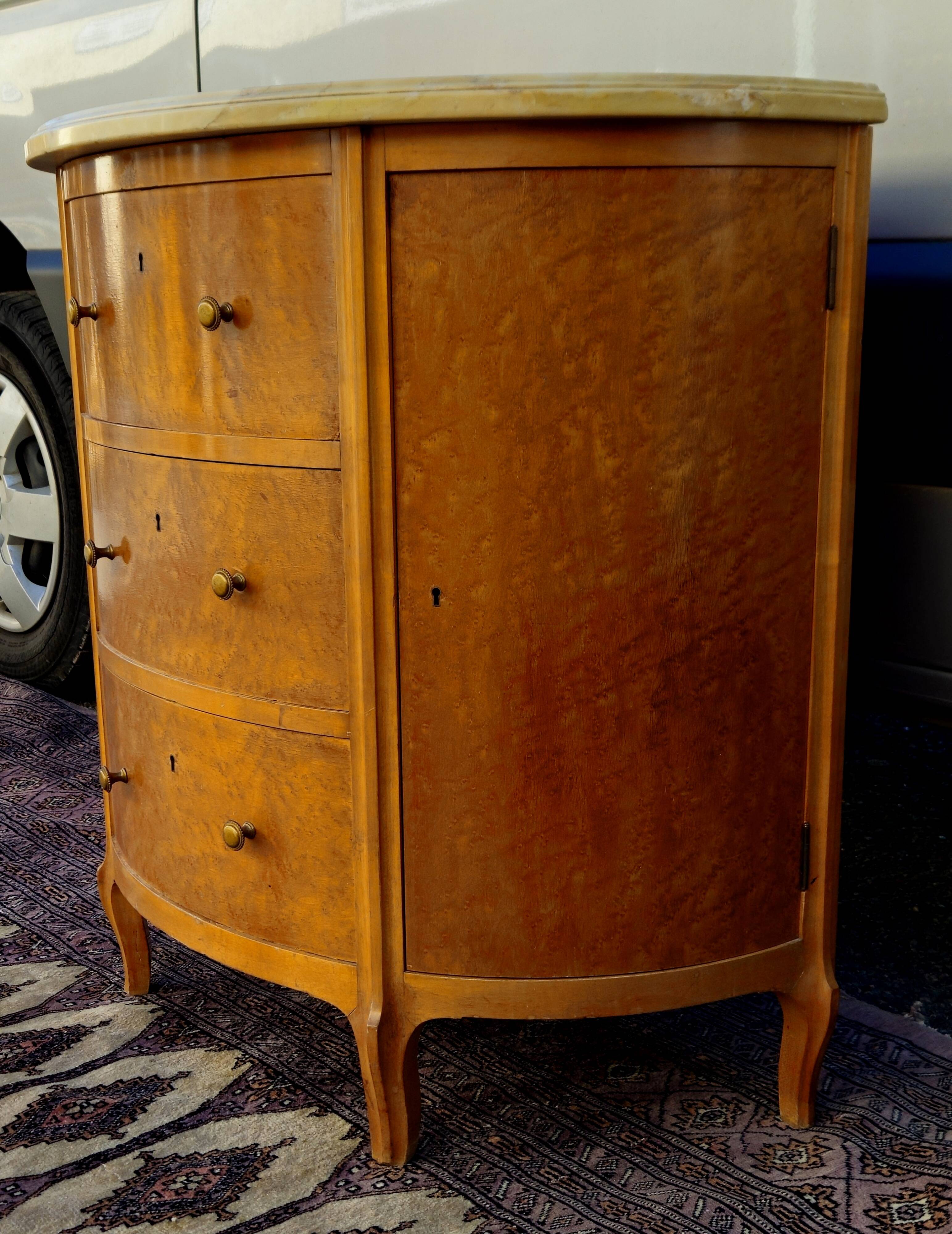 Half-moon commode in burl wood with a marble top.