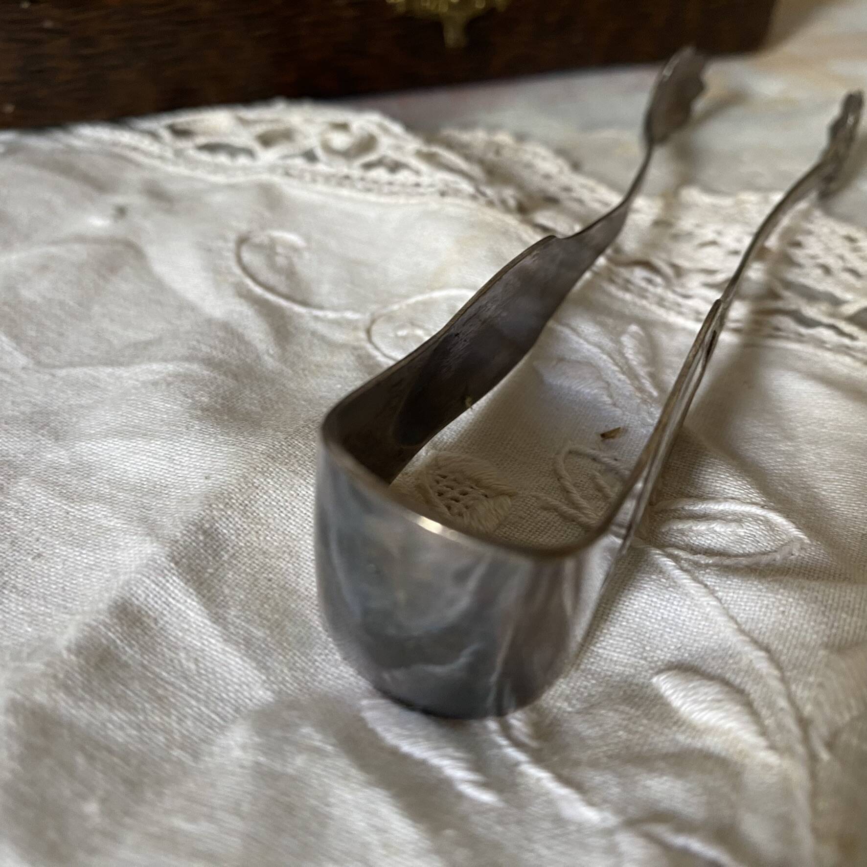 Antique sugar tongs in its case, shell decoration.