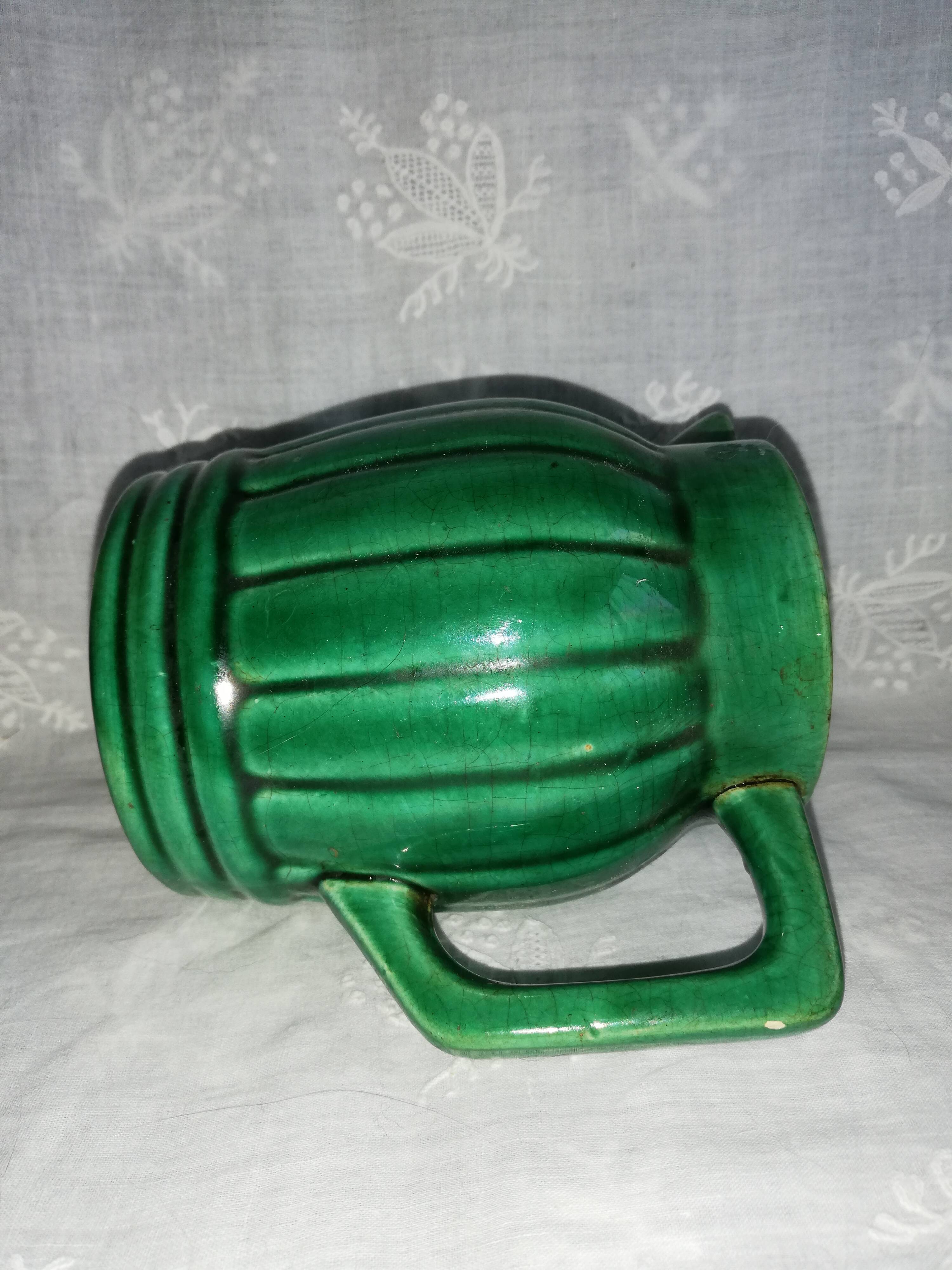 Old green pitcher in dabbling