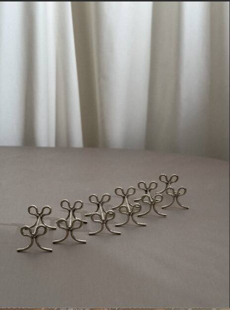 Set of six silver-plated ribbon-shaped knife rests. 20th century
