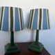 Pair of vintage wooden lamps with their striped beige, blue, and green shades.