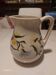 Earthenware jug with floral motifs in the Moustiers style, signed.