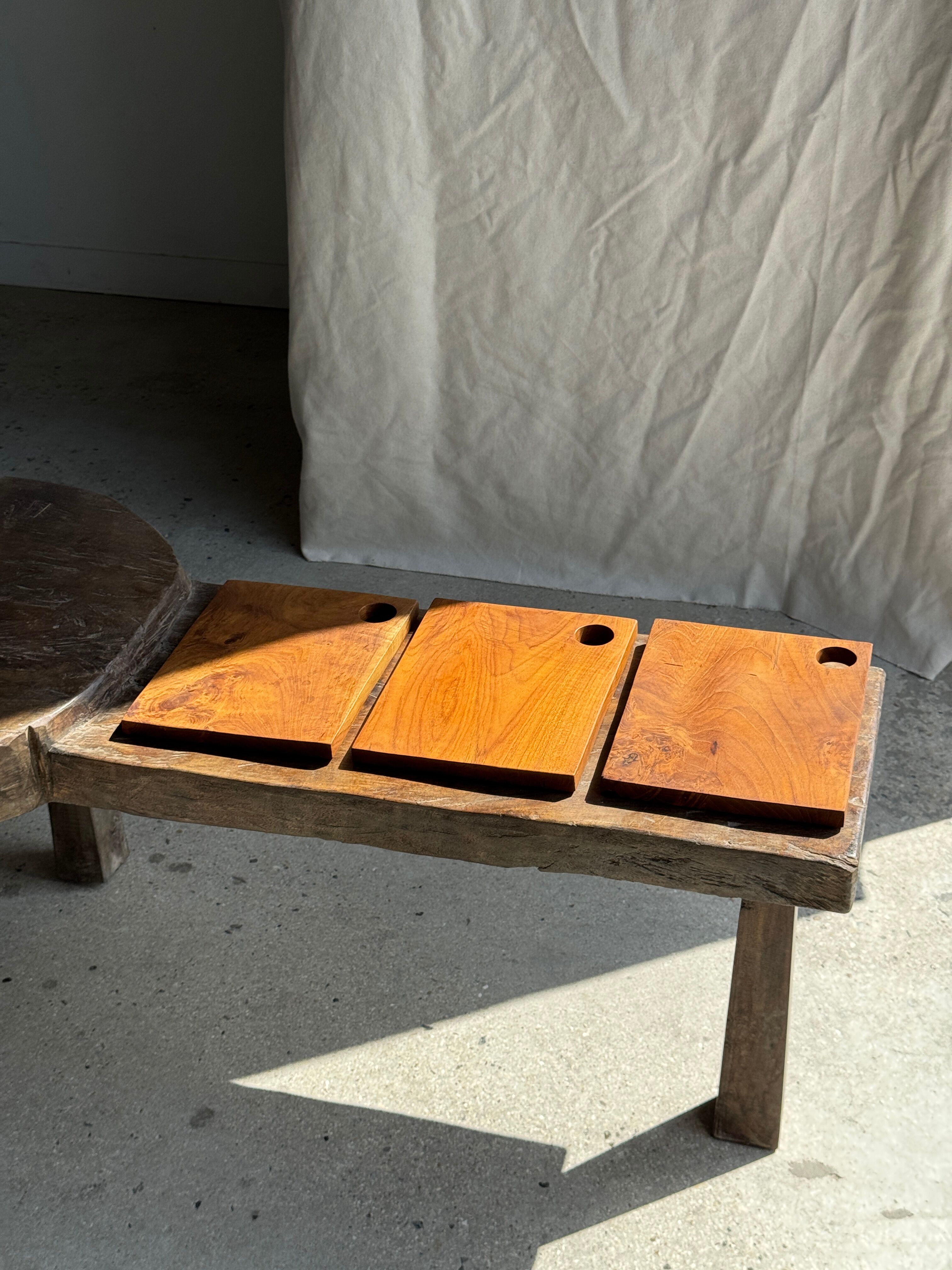 Small rectangular teak monoxyle cutting board with a circular handle.