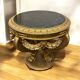 A round Louis XV style table in carved gilt beechwood with a black marble top