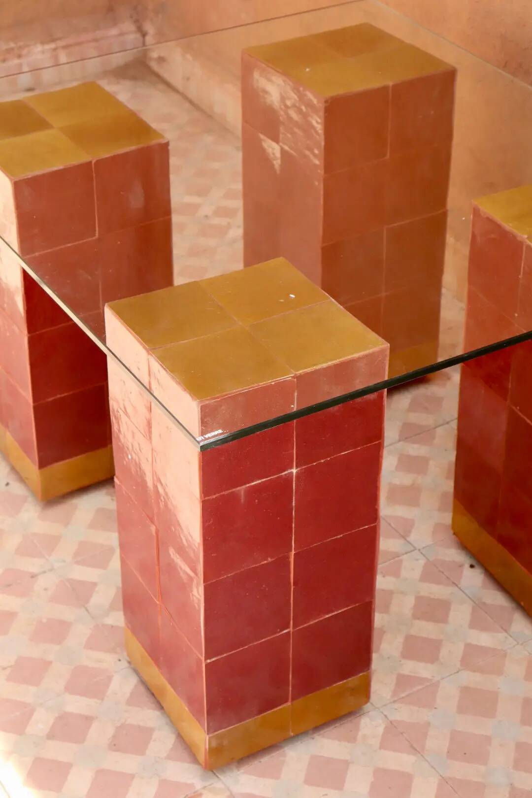 Modern coffee table in burgundy zellige with a tempered glass top.