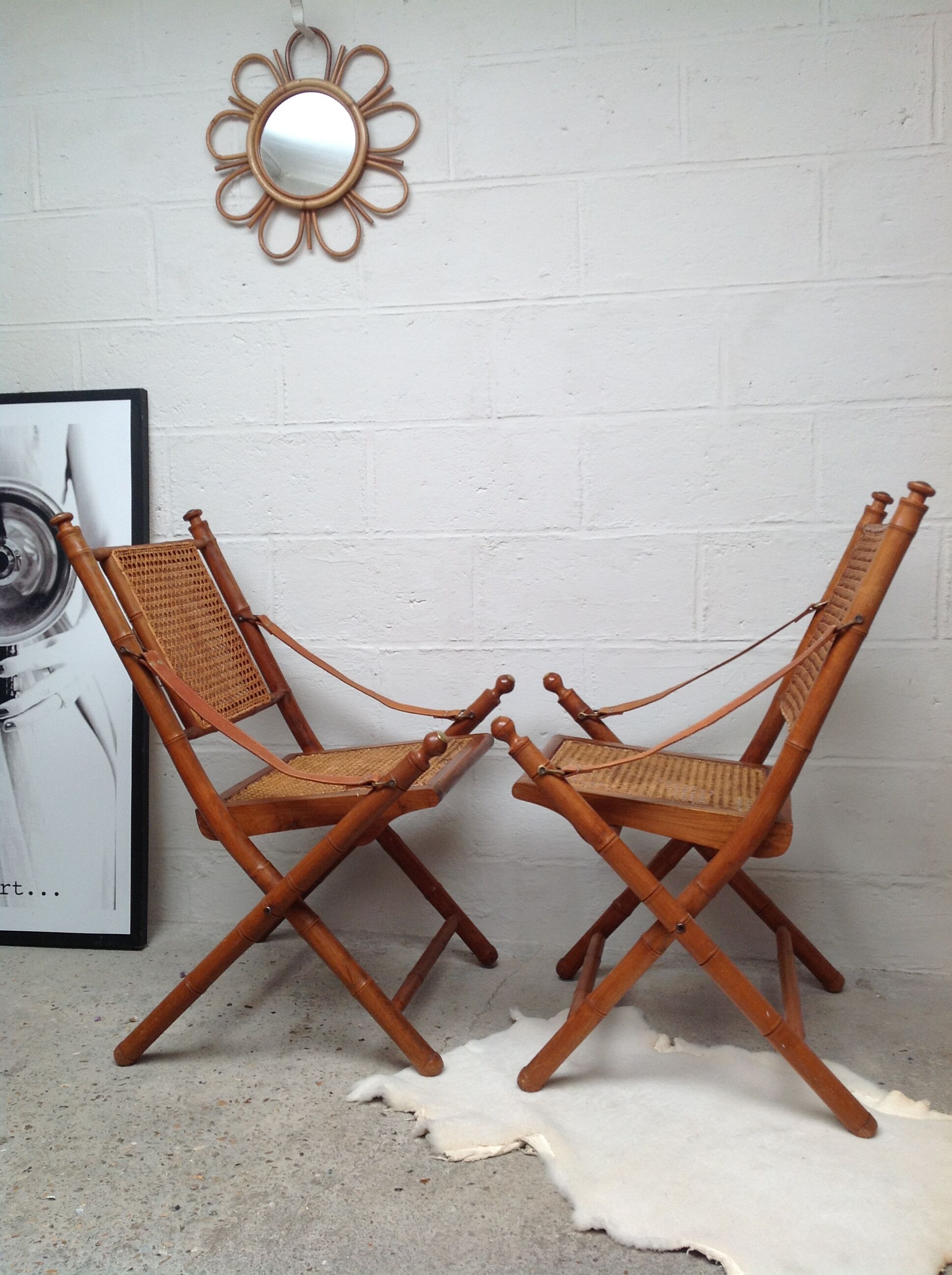 Pair of folding chairs in bamboo and caning, leather and brass
