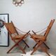 Pair of folding chairs in bamboo and caning, leather and brass