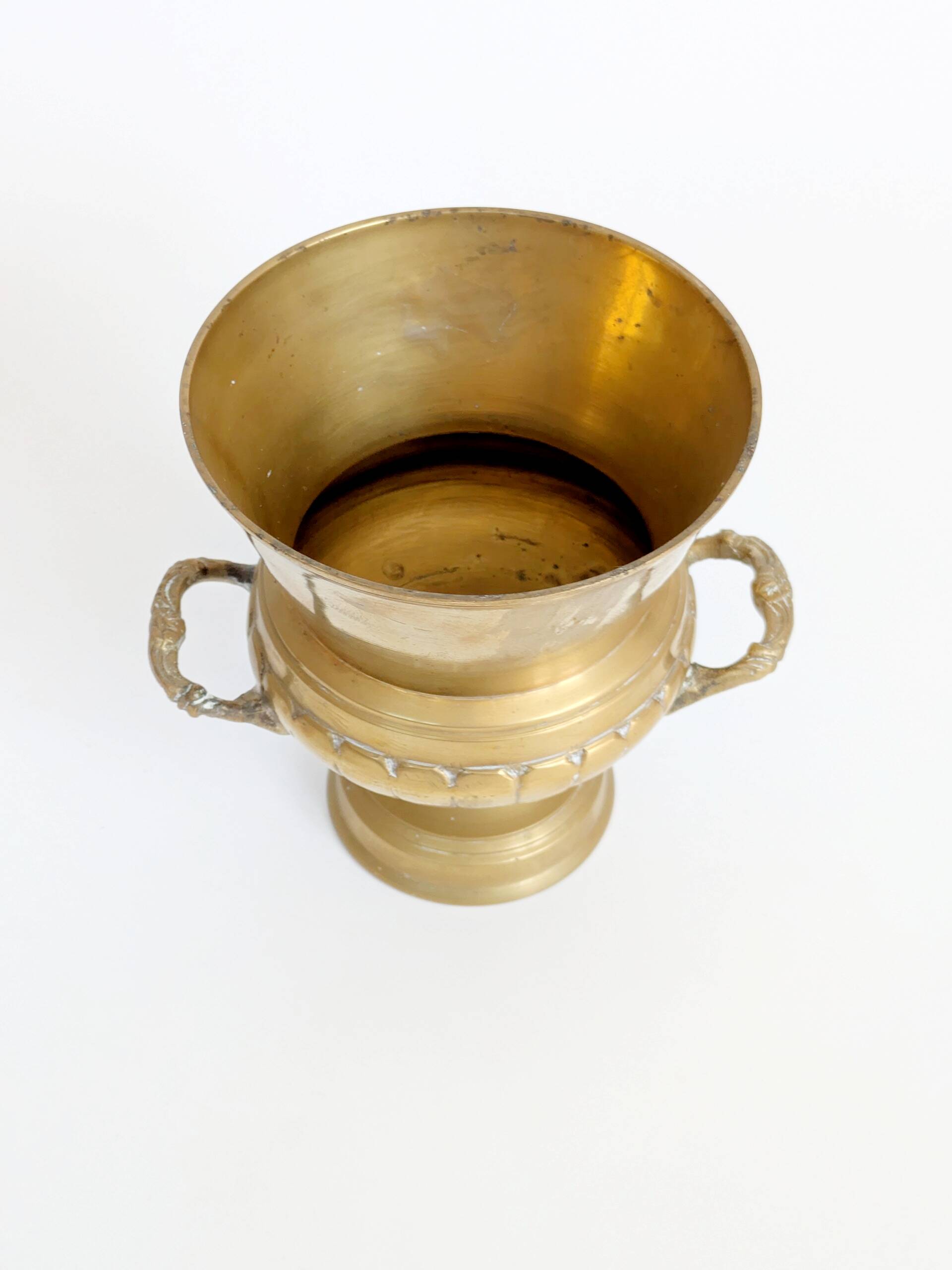 Vintage brass cache-pot on a stand with handles, classic decor.