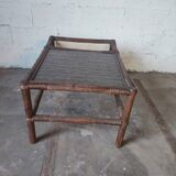 Relaxed armchair in bamboo and rattan with its small side table. Beige linen cushion.
