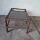 Relaxed armchair in bamboo and rattan with its small side table. Beige linen cushion.