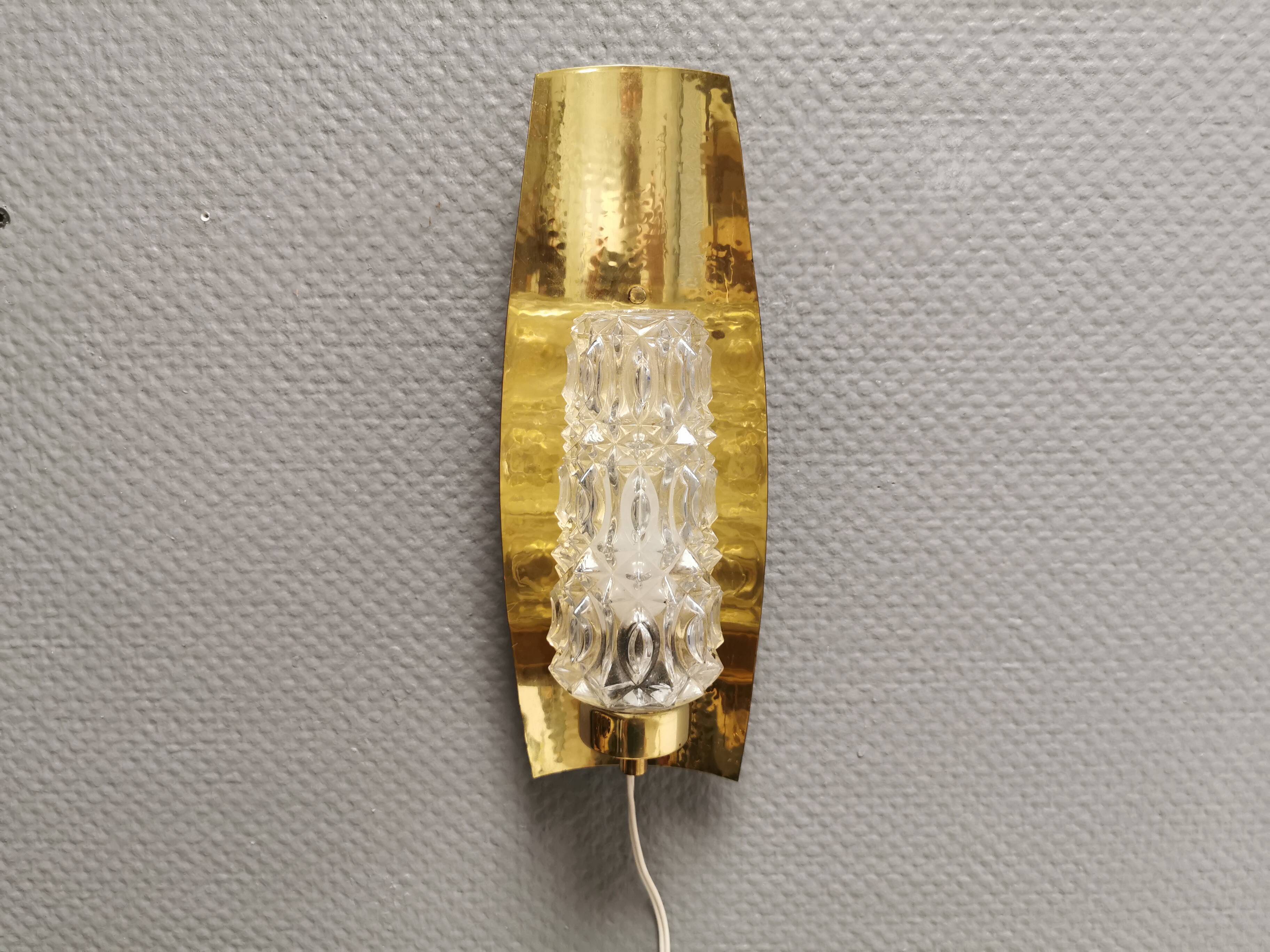Older wall lamp in brass with hard pressed glass shade.