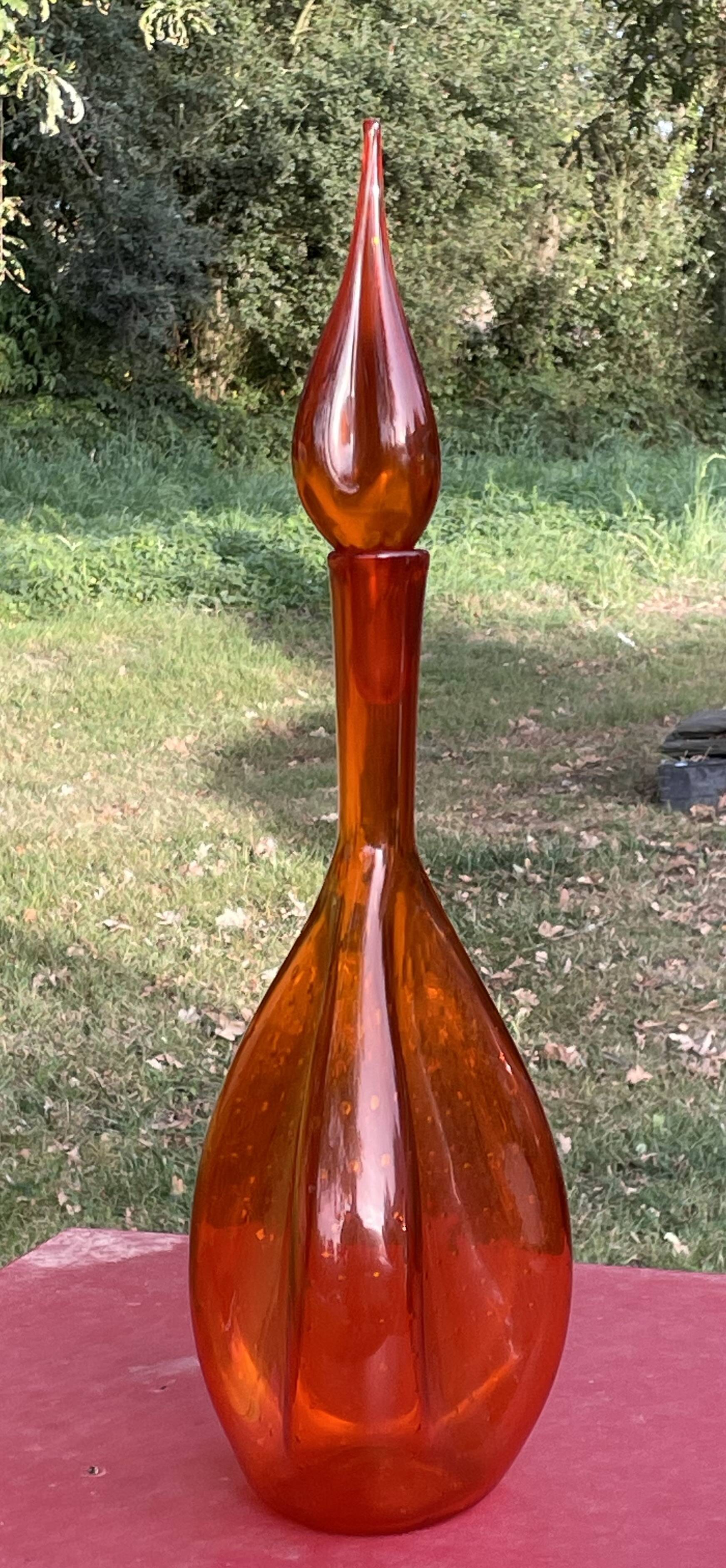 Orange bubbled glass bottle with curved body, circa 1970