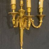 Pair of gilt bronze wall sconces with three lights in the Louis XVI style.