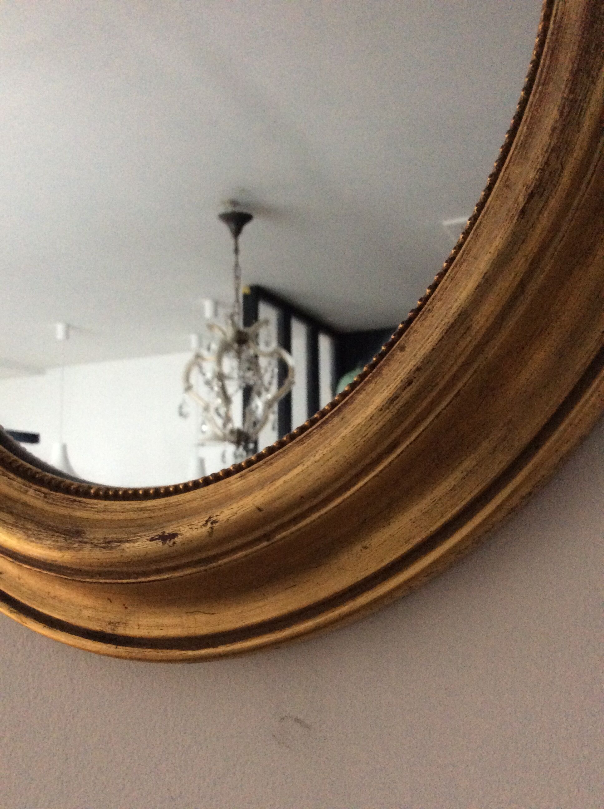 Old oval mirror in gilded wood