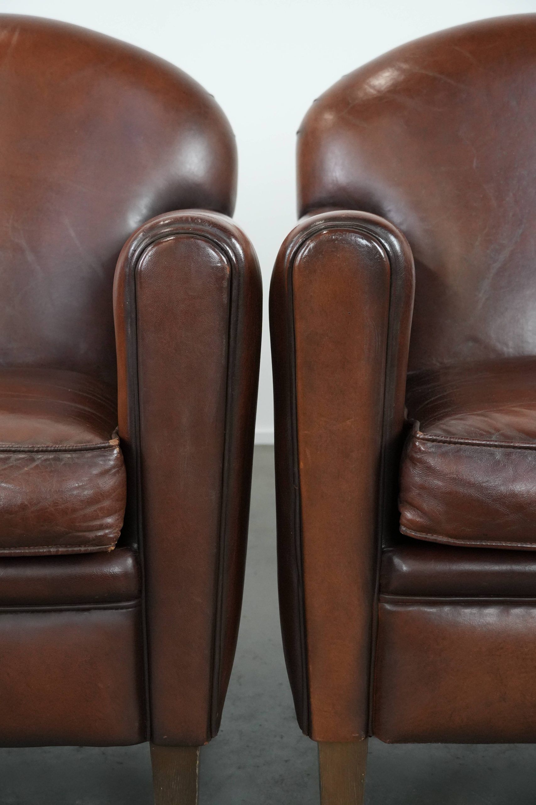 Ensemble de 2 fauteuils en peau de mouton au design art déco avec des couleurs chaudes.