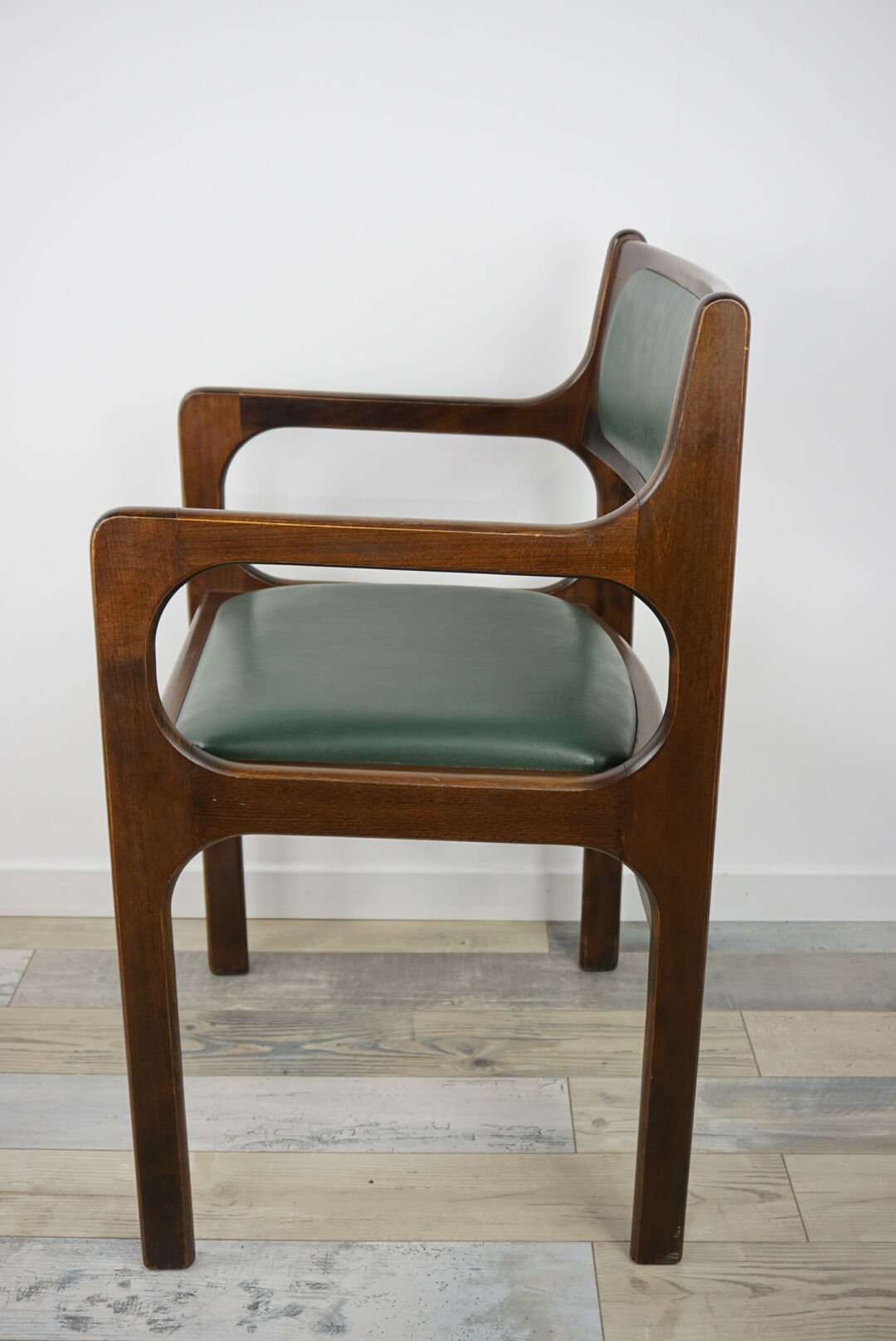 Armchair of the 60s in wood and imitation dark green leather
