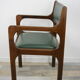 Armchair of the 60s in wood and imitation dark green leather