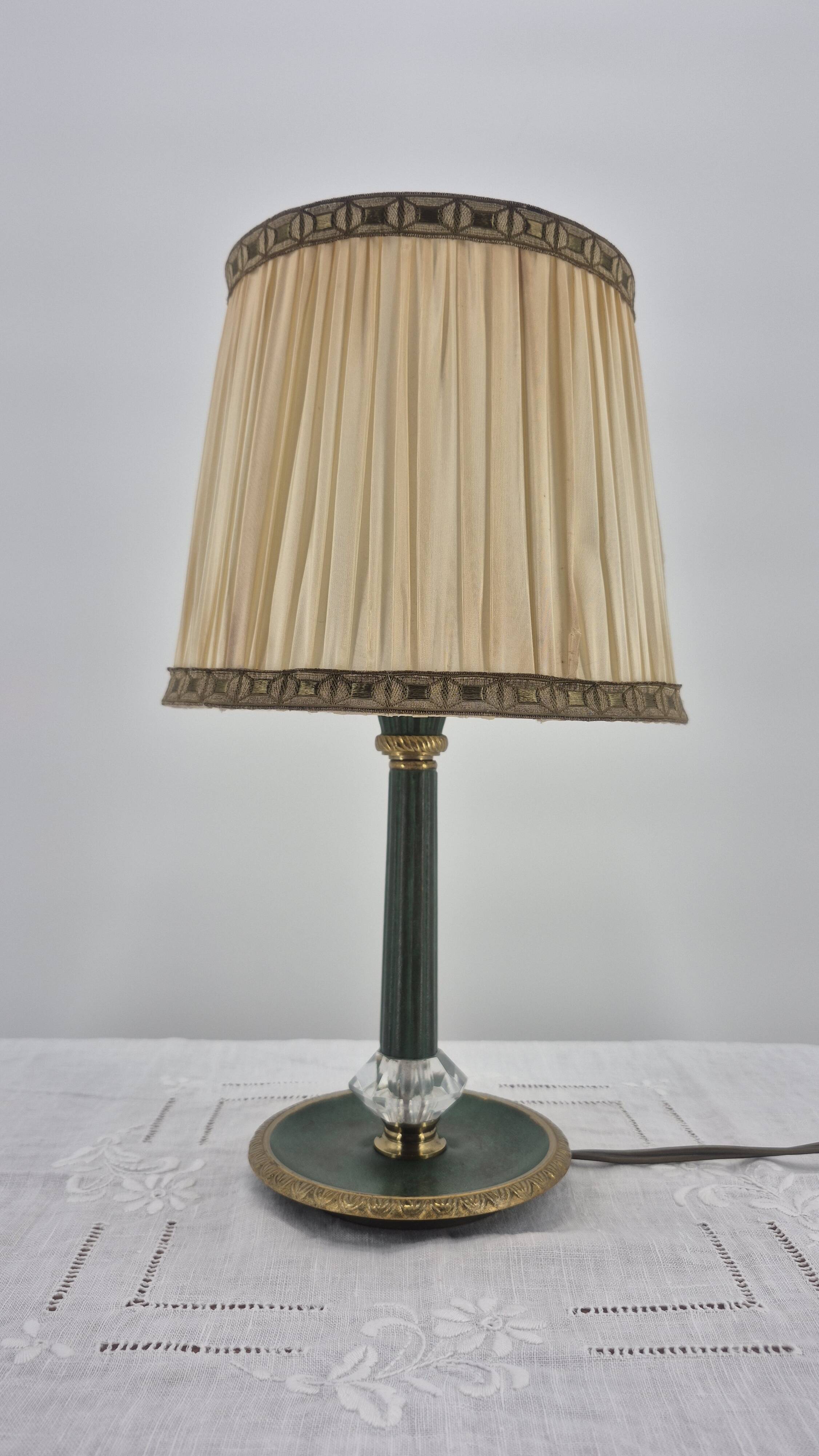 Brass table lamp with green patina and empire-style fabric shade.