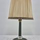Brass table lamp with green patina and empire-style fabric shade.