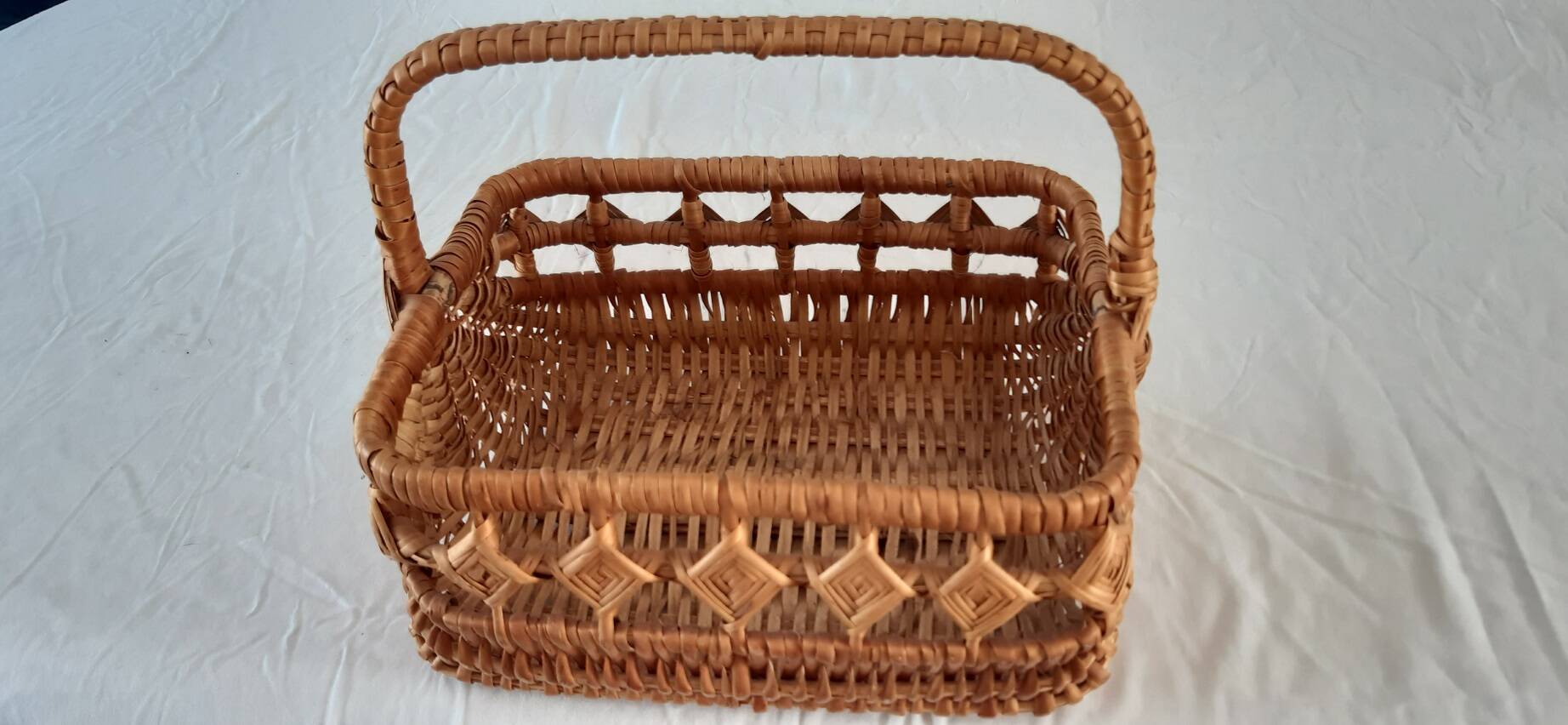 Old wicker basket with diamond-shaped decorations