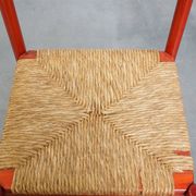 Vintage 1970s red wooden chair with a woven wicker seat