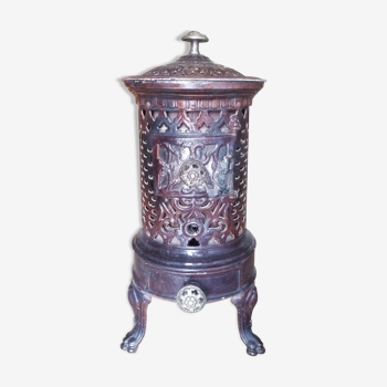 Old compact wood stove in enamelled cast iron with tripod feet with Lion's legs