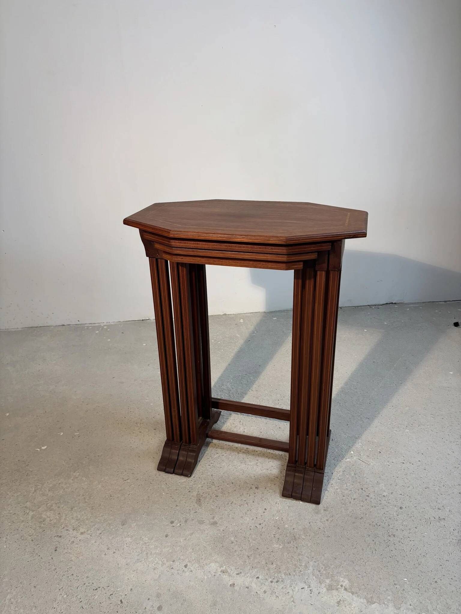 Four nesting tables with polygonal tops and decorative inlays.