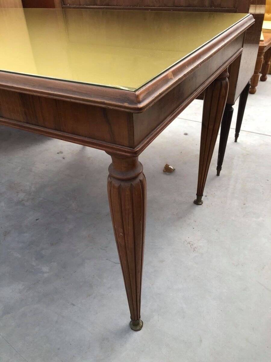 Dining table in the style of Paolo Buffa, made of brown wood with a tinted glass top.