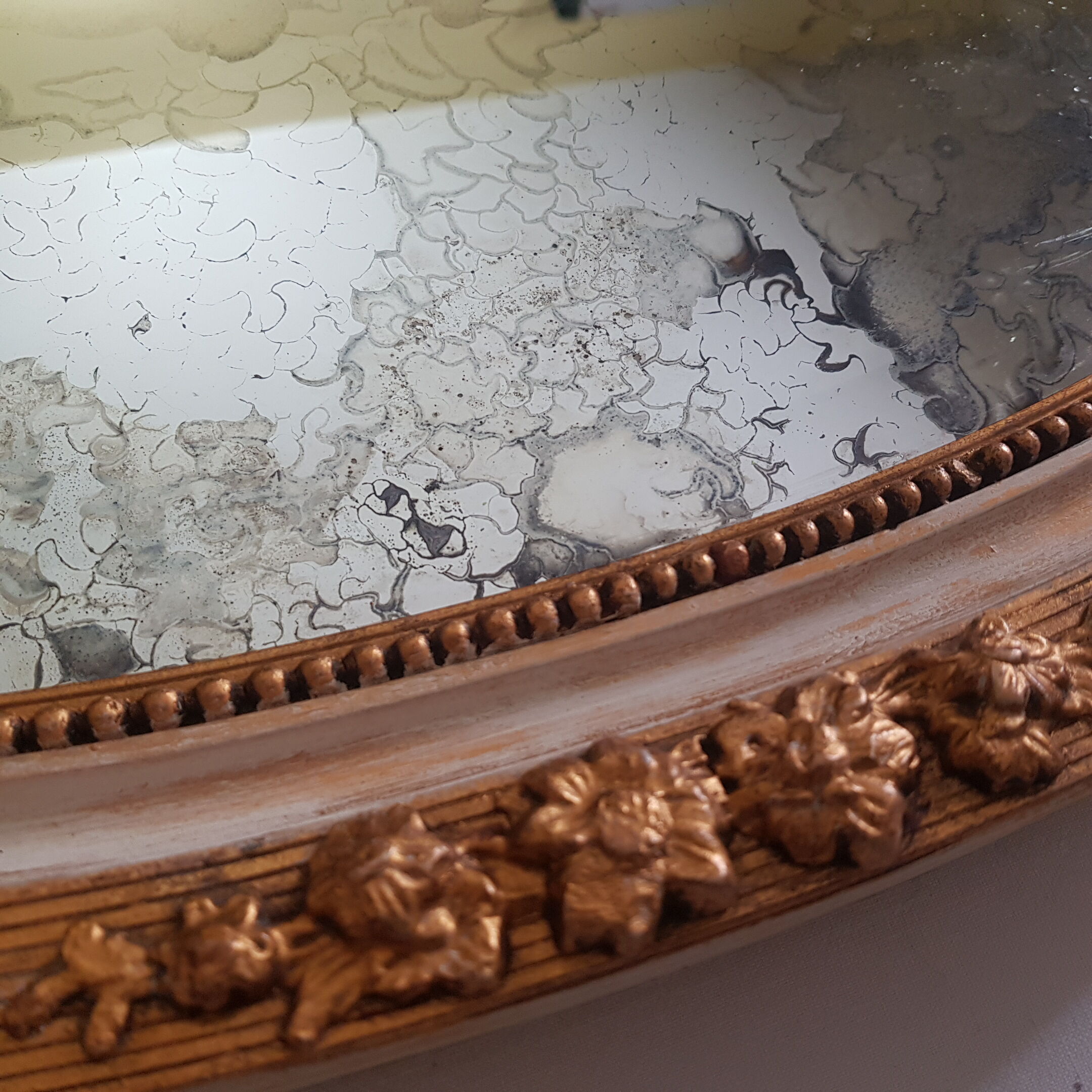 Large oval mirror with bevelled ice in stucque and wood decorated with flowers