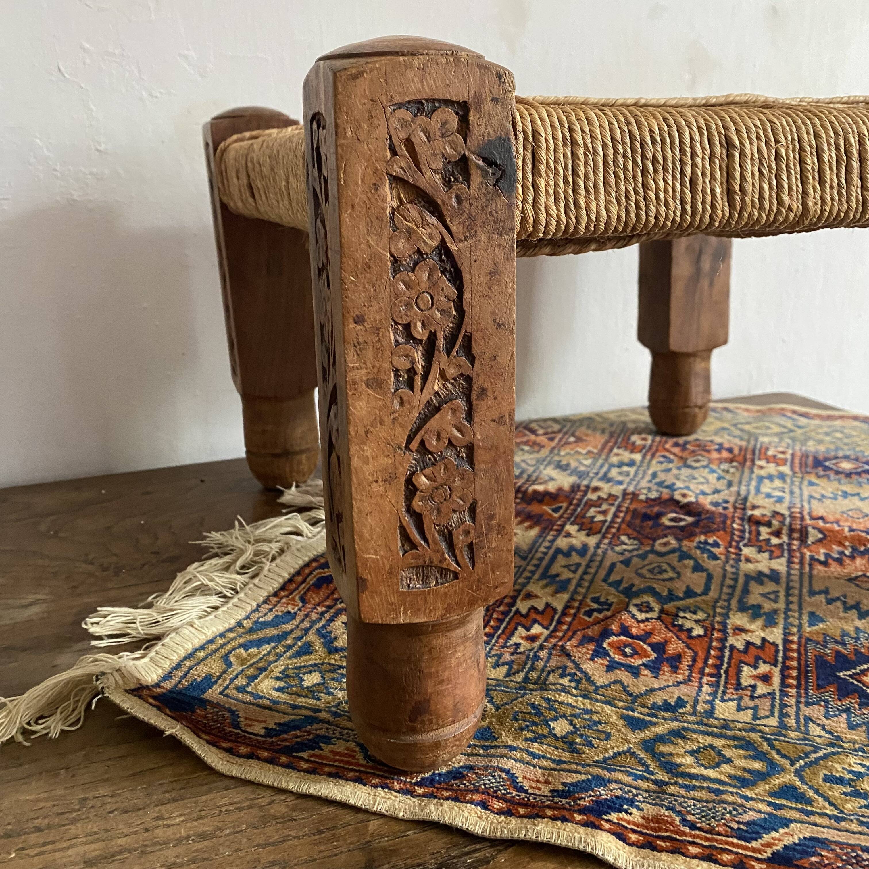 Low stool with carved wood and braided cord.