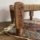 Low stool with carved wood and braided cord.
