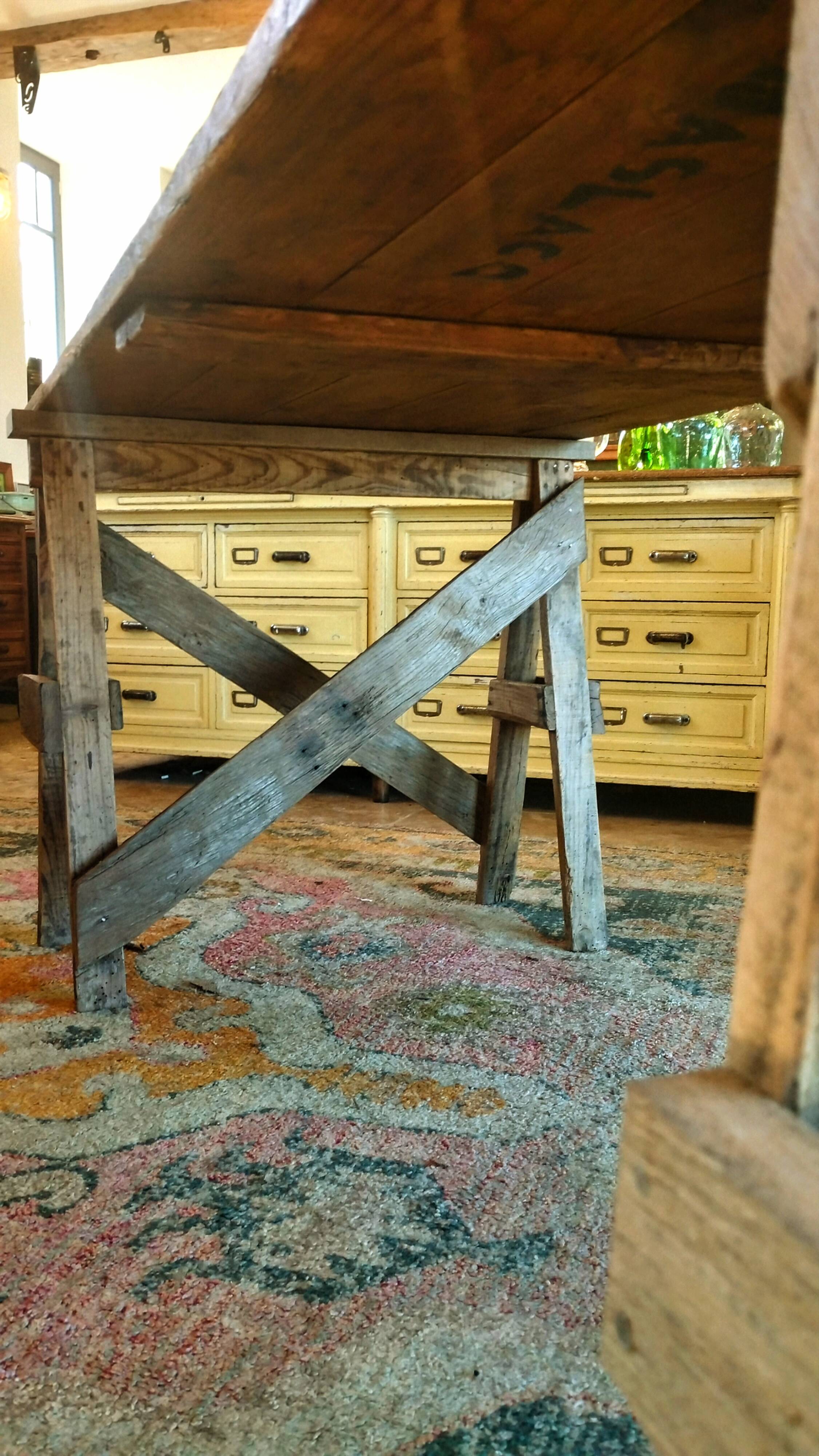 Table de ferme rustique patinée sur de lourds tréteaux