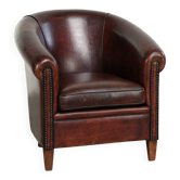 Vintage sheepskin club armchair with decorative nails and black piping