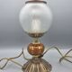 Hollywood Regency bedside lamp in gold metal with a glass globe.