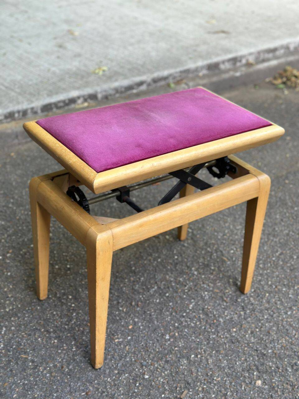 Adjustable piano stool in light beech and purple velvet.
