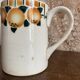 Old ceramic pitcher with orange decoration.