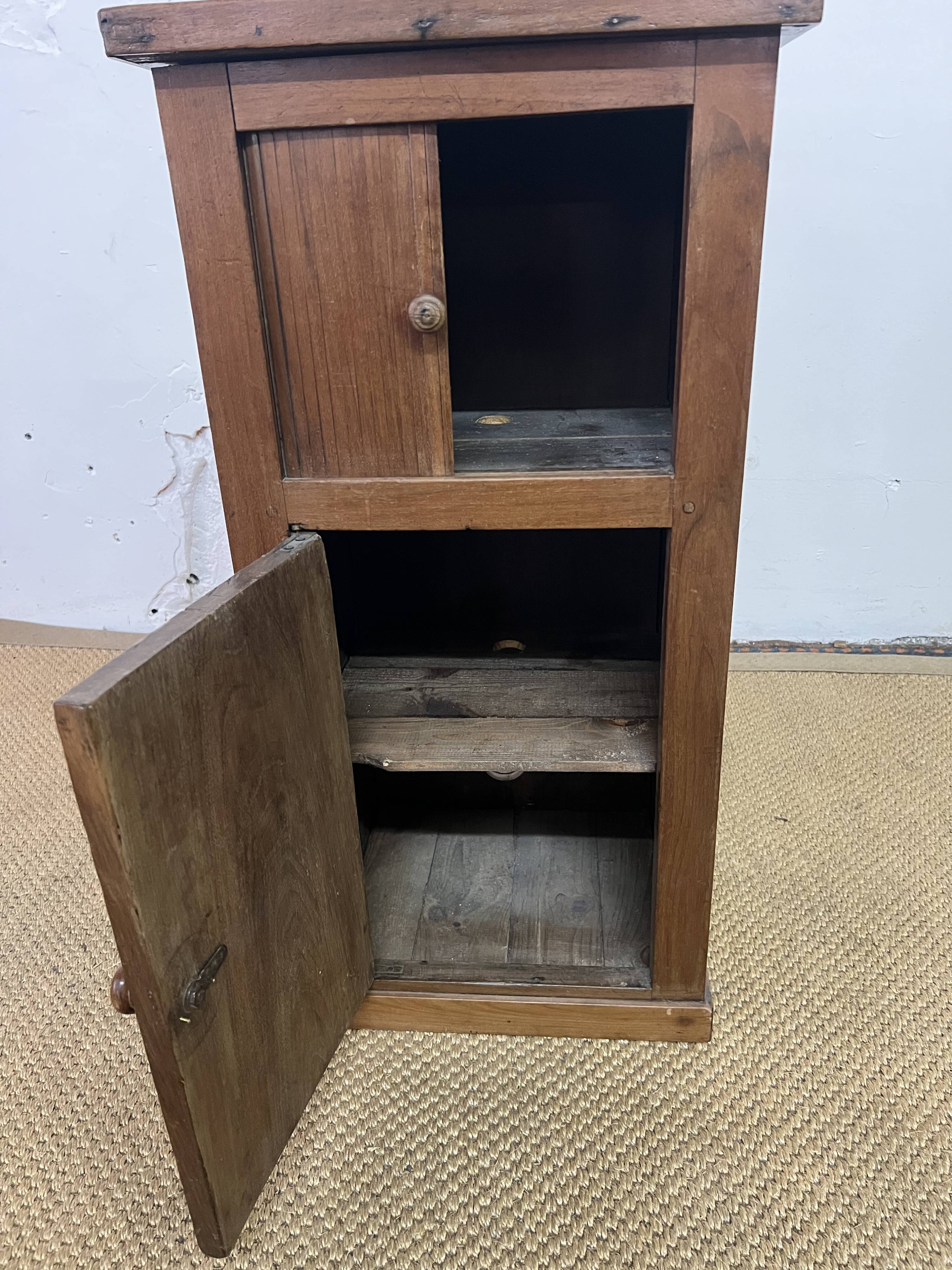 Old small storage unit with sliding and hinged doors.