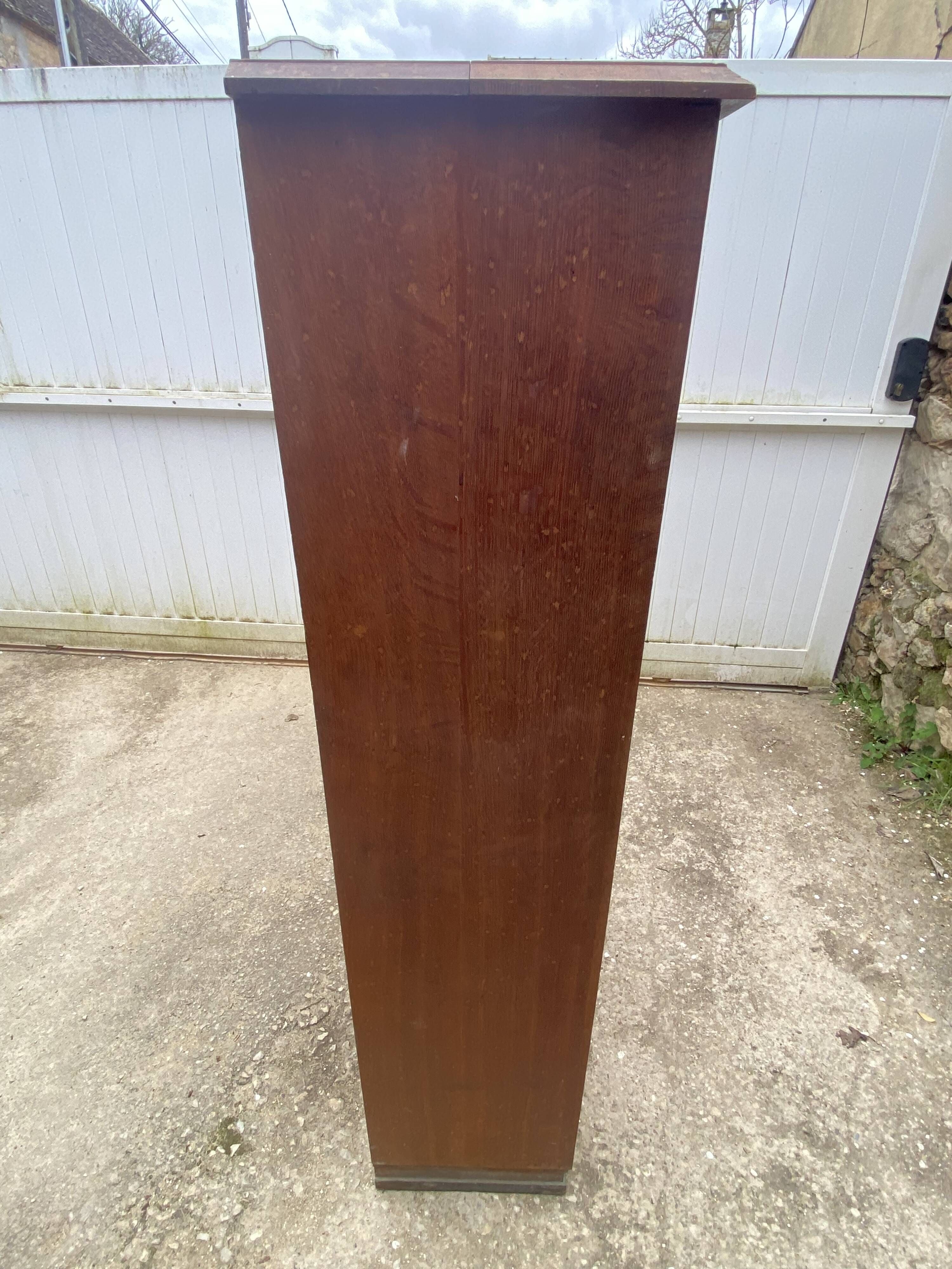 Oak two-column filing cabinet with curtains.