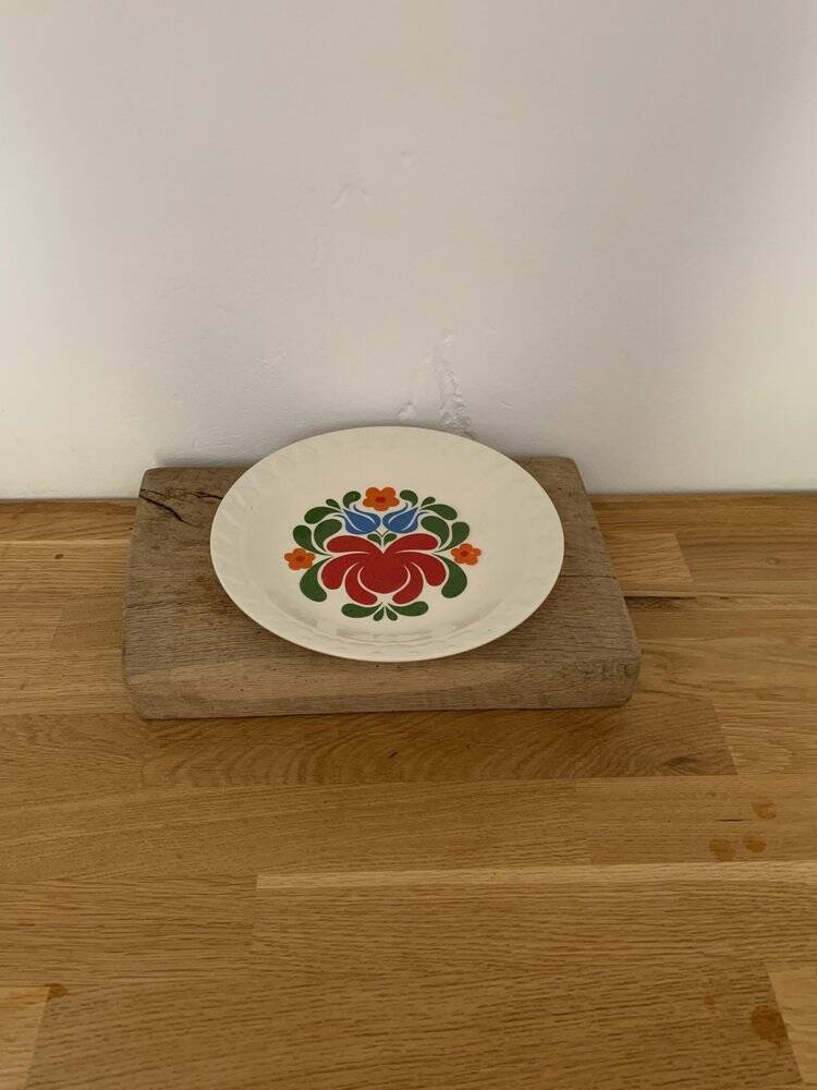 Hungarian folk plate in white ceramic with hand-painted flowers, embossed edge.