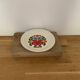 Hungarian folk plate in white ceramic with hand-painted flowers, embossed edge.