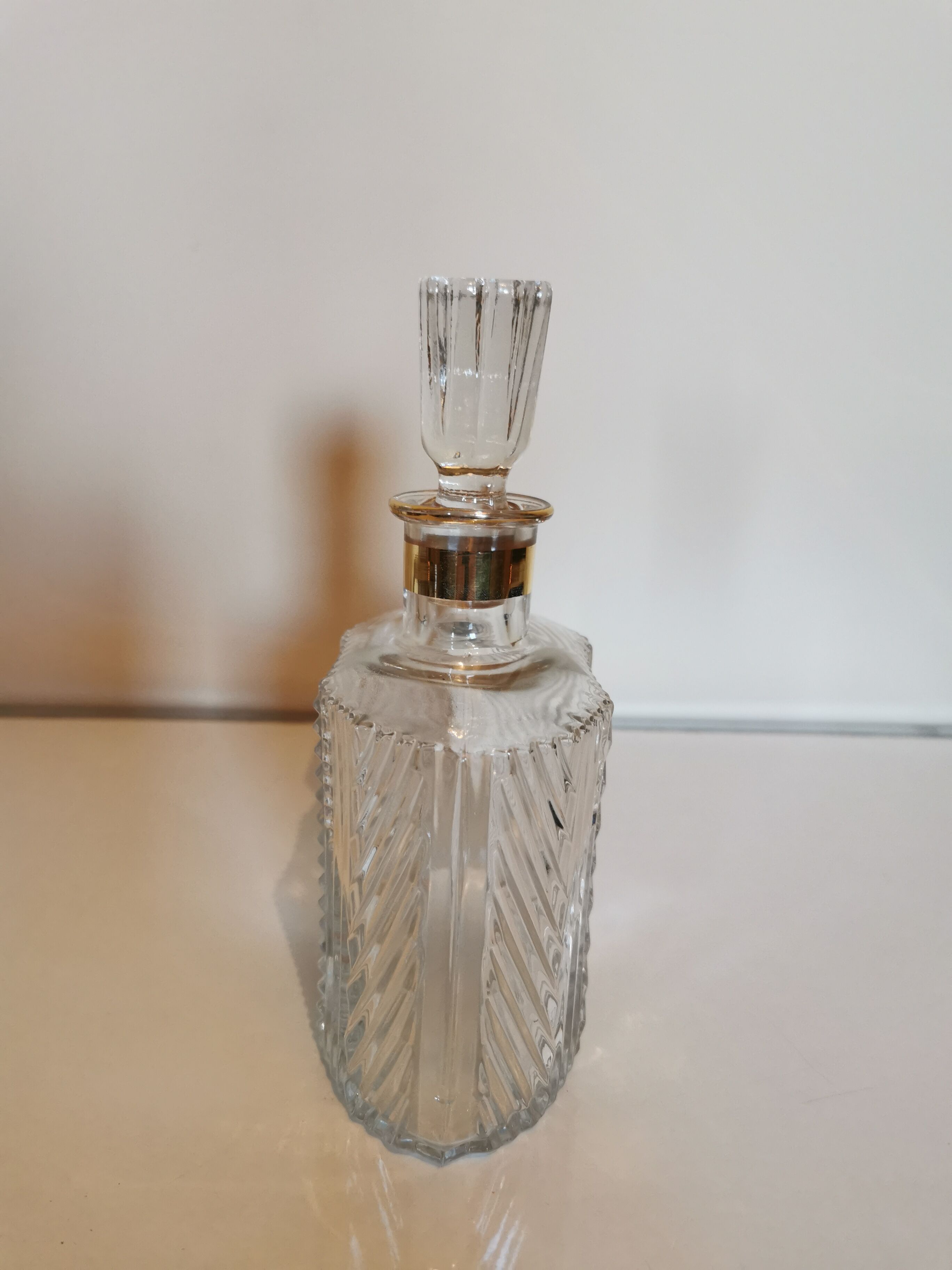 Carved glass decanter, golden band on the collar