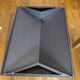 Minimalist/industrial coffee table with a black metal frame and a grey fabric top.