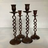 Four twisted metal candle holders with a rusty appearance