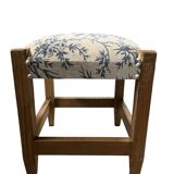 Square pouf with a checkered pattern.