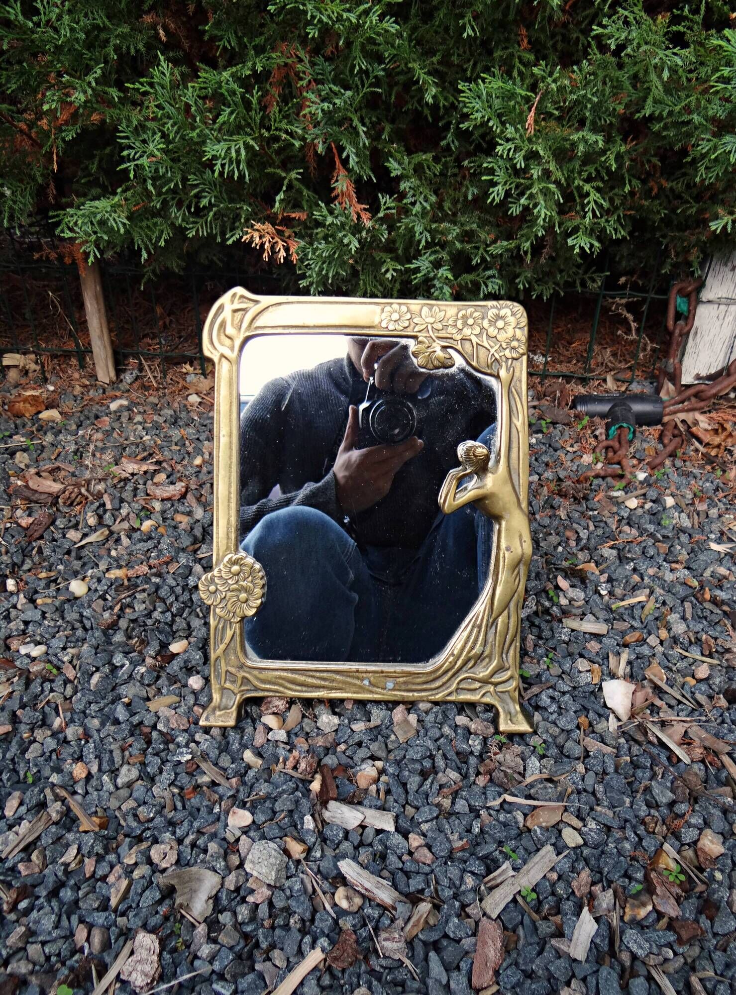 Art Nouveau mirror in gilded brass with a woman figure emerging from a vintage frame