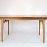 Dining table in teak and oak with extensions designed by Hans J. Wegner