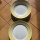 Two earthenware dishes, one hollow and one white cake dish with yellow border